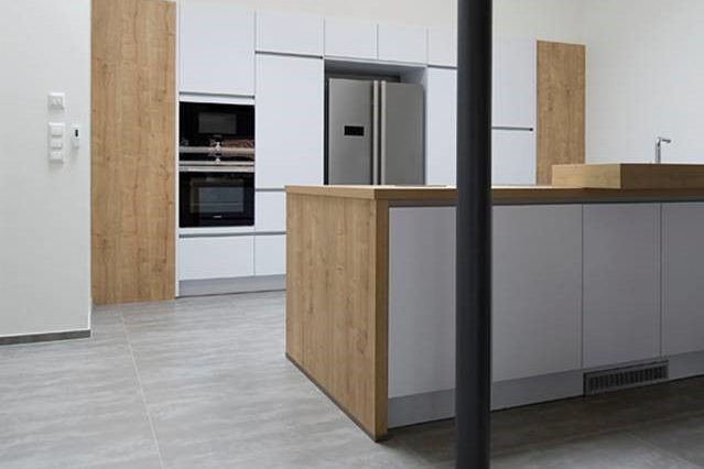 Küchenboden hygiensch durch Fliesenbelag Moderne Küche mit Holz- und weißen Möbeln, inklusive Kühlschrank und Backofen.