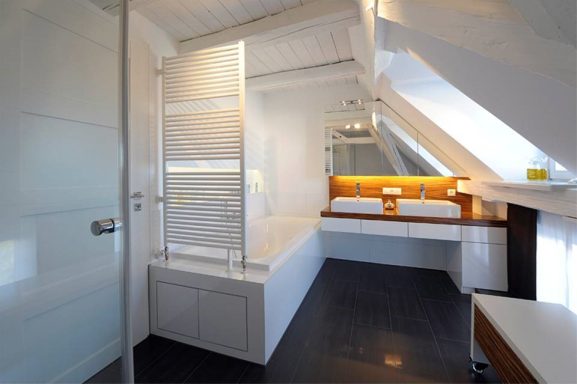 Modernes Badezimmer mit zwei Waschbecken und Dachschräge, hell und minimalistisch gestaltet.
