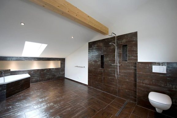 Modern Badezimmer mit Dusche, Badewanne und Holzdecke. Elegante, dunkle Fliesen.