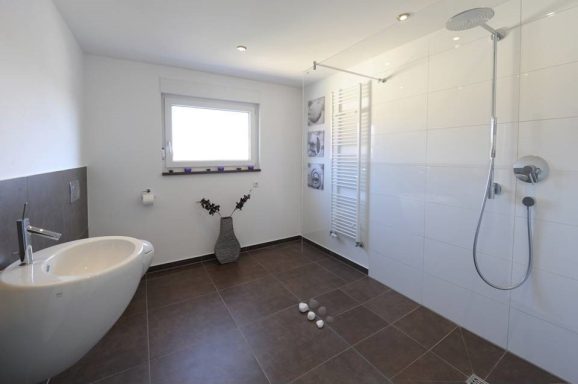 Modernes Badezimmer mit Dusche, Toilette und bidetähnlichem Waschbecken.