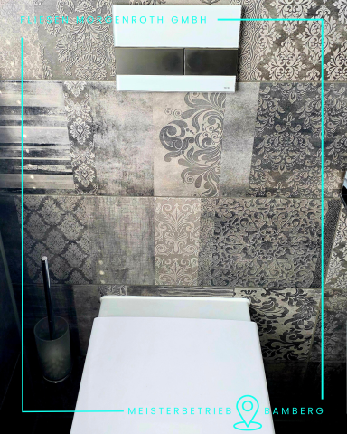 Badsanierung - barrierefrei Moderne Toilette mit grauen Fliesen und stilvollem Wanddesign.