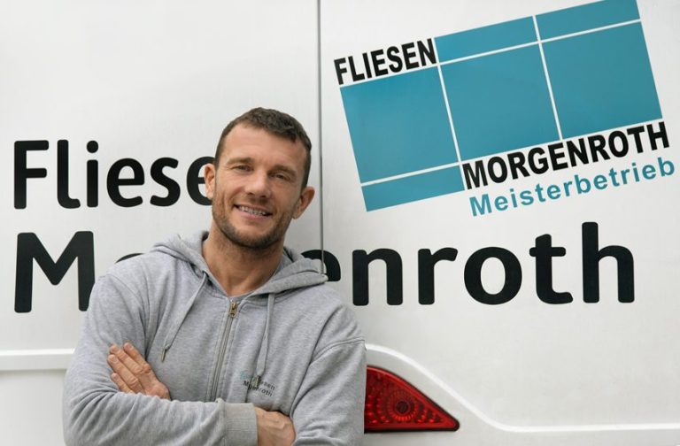 Fliesenmeister Sven Morgenroth Lächelnder Handwerker steht neben einem Fahrzeug mit der Aufschrift „Fliesen Morgenroth“.