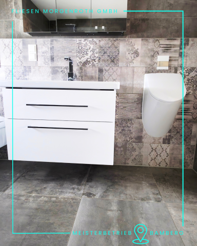 Badsanierung - barrierefrei Moderne Badezimmer mit weißem Unterschrank, Waschbecken und stilvollem WC.